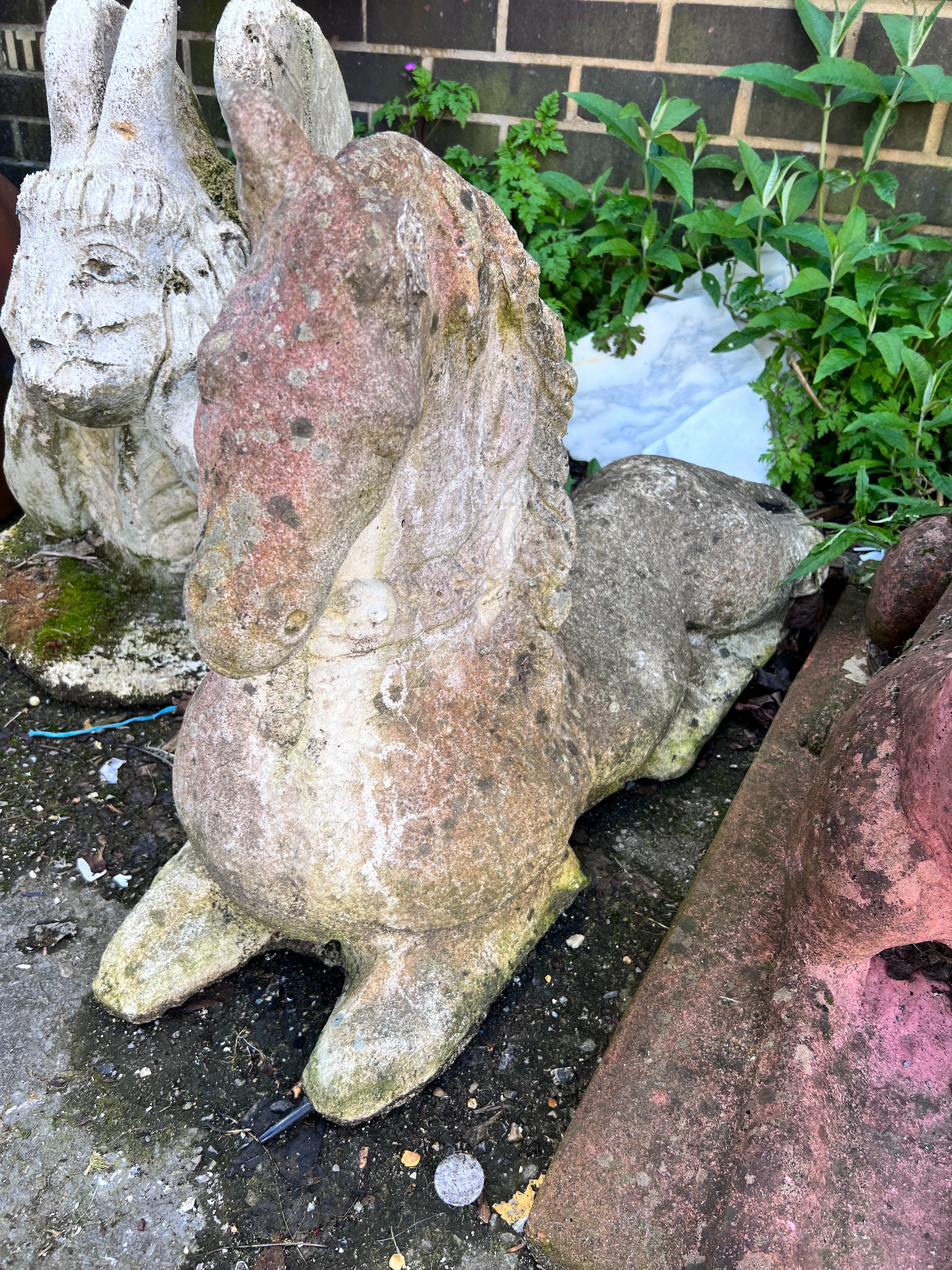 A reconstituted stone recumbent horse, height 55cm *Please note the sale commences at 9am.
